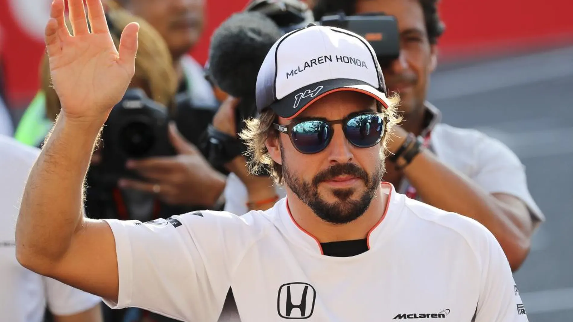 El piloto español Fernando Alonso, del equipo McLaren Honda, saluda al público durante la tradicional firma de autógrafos previa al Gran Premio de Fórmula Uno de Japón