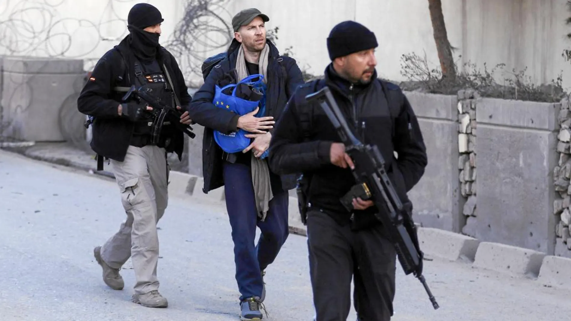 Fuerzas de seguridad escoltan a miembros de la Embajada española en su salida del edificio el día del atentado en diciembre de 2015