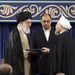 El presidente de Irán, Hasan Rohaní, recibe un certificado sobre su nombramiento de manos del líder supremo iraní, el ayatolá Alí Jameneí