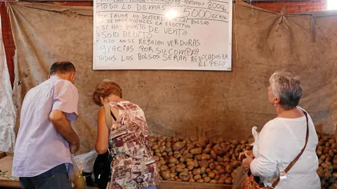 Venezolanos buscan alimentos de primera necesidad en un mercado en Caracas, ayer