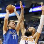 Doncic, con el número 77 de los Mavericks, se estrella con la defensa de Chandler de los Suns