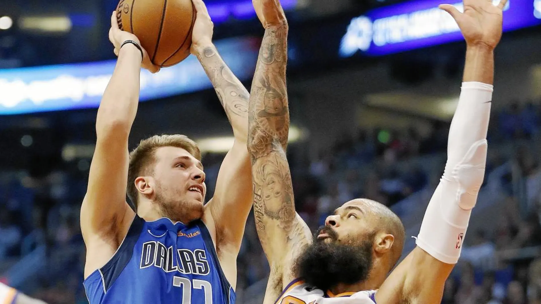 Doncic, con el número 77 de los Mavericks, se estrella con la defensa de Chandler de los Suns