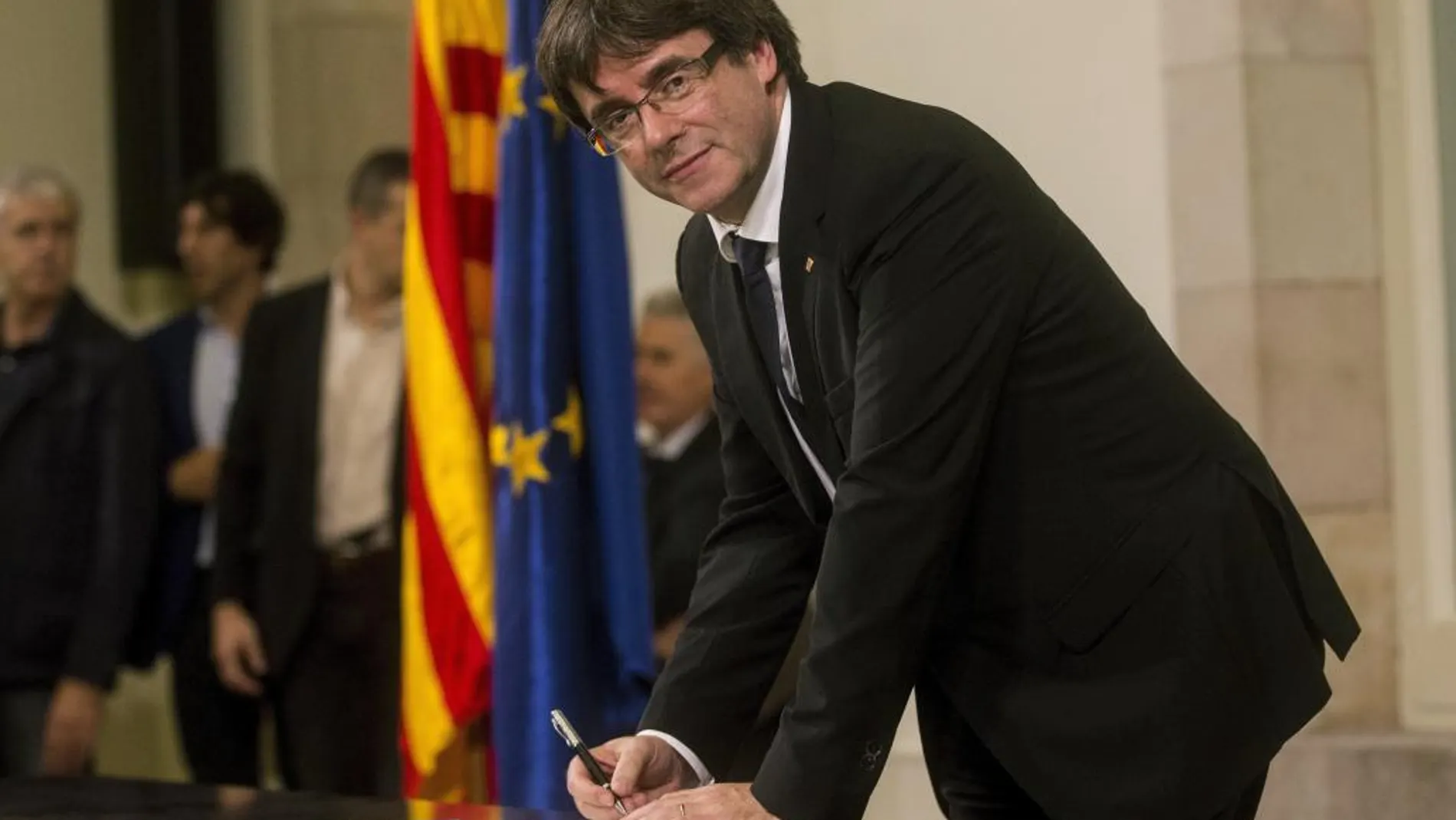 El presidente de la Generalitat, Carles Puigdemont, firma el documento sobre la Independencia después de comparecer ante el pleno del Parlament para trasladar los resultados de la jornada del 1-O.