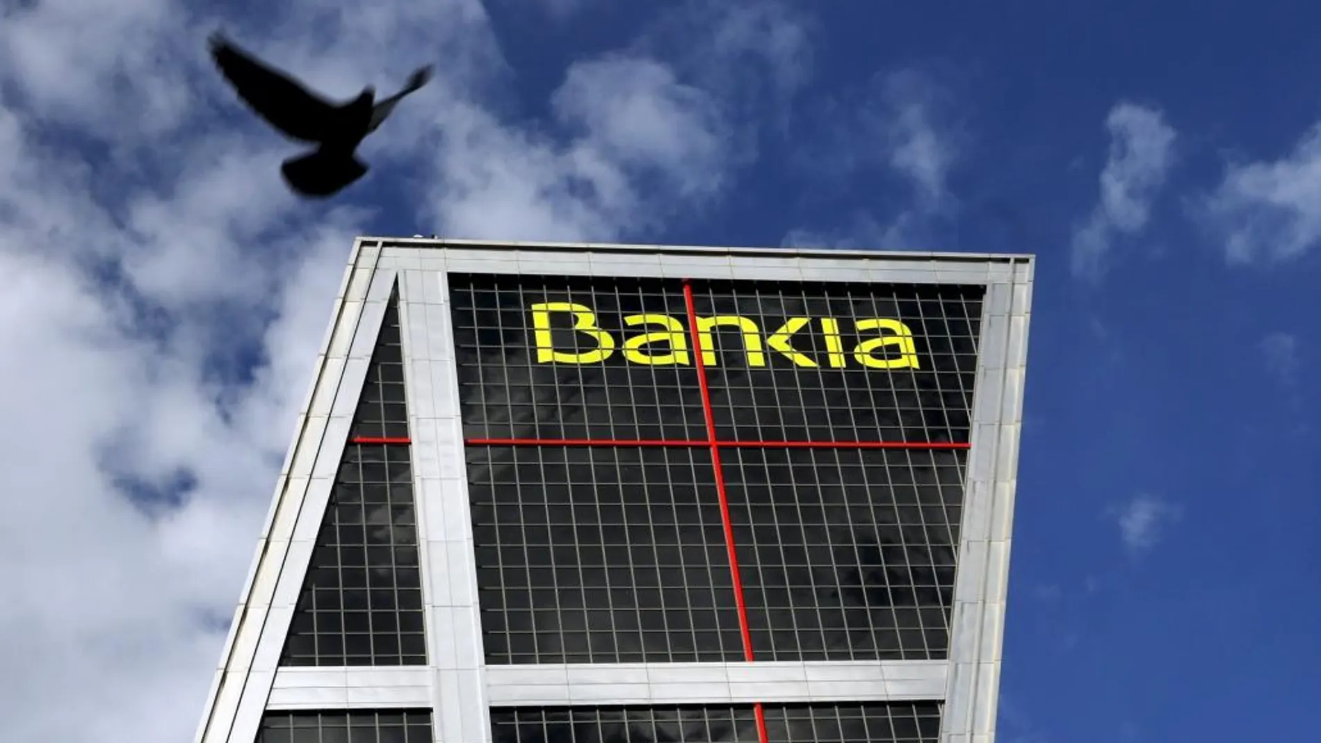 A dove flies near the headquarters of Spanish nationalised lender Bankia in Madrid, Spain, February 17, 2016. REUTERS/Susana Vera