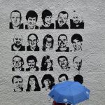 Una mujer pasa ante un grafiti con los rostros de los presos de ETA.