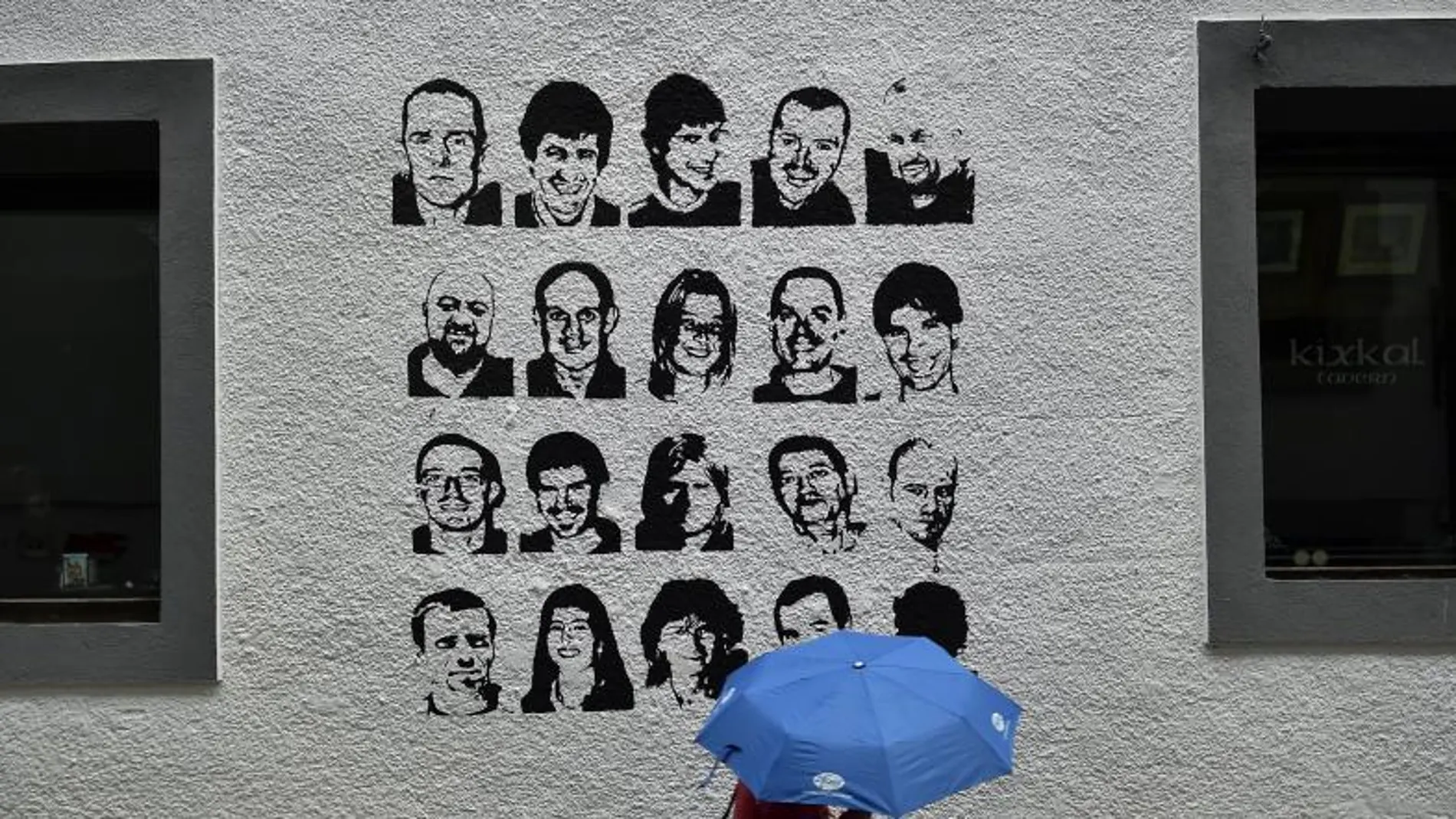 Una mujer pasa ante un grafiti con los rostros de los presos de ETA.