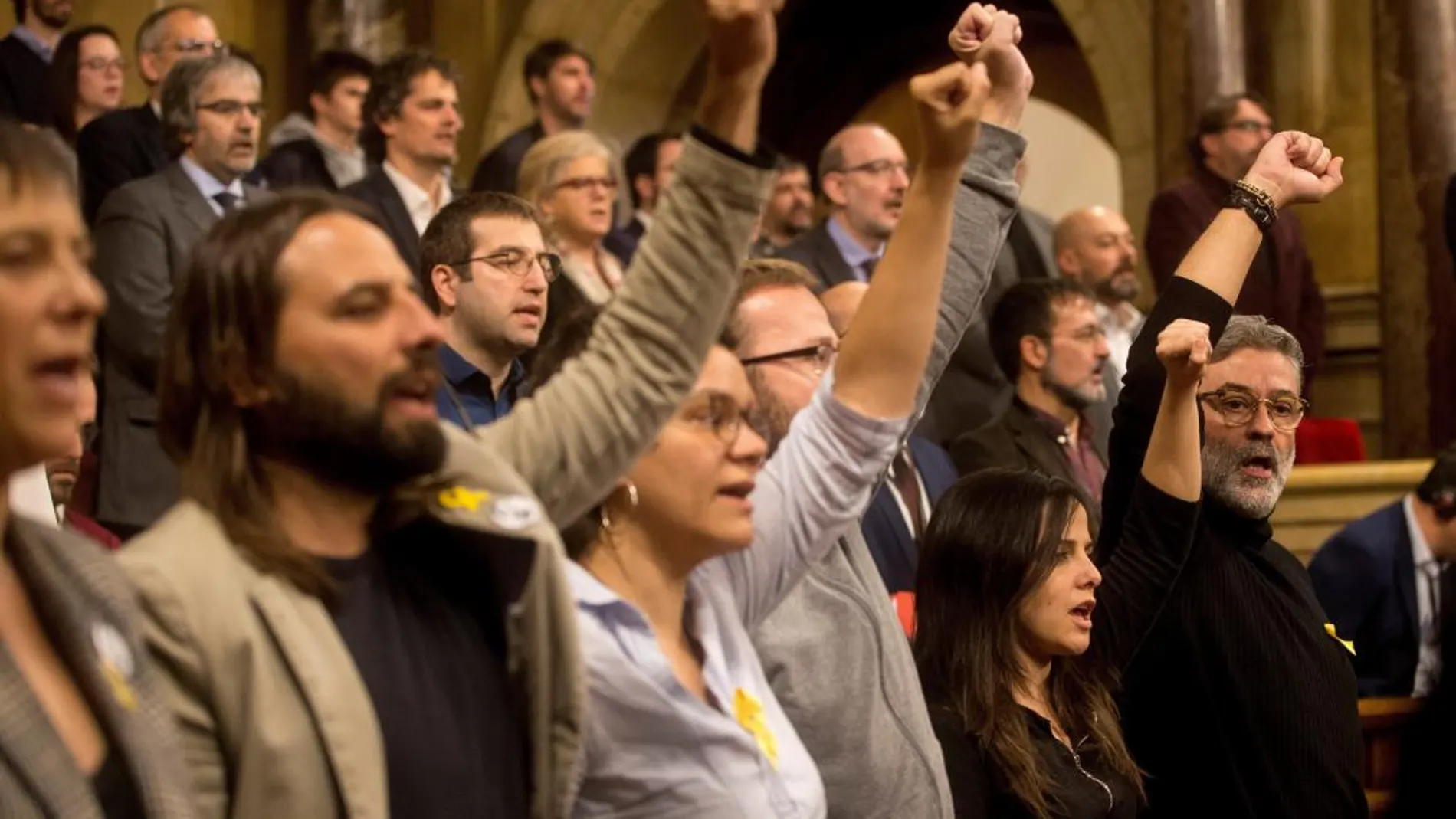 El diputado de la CUP Carles Riera (d) y los demás miembros de la formación cantan "Els Segadors", puño en alto, al finalizar el pleno de constitución de la XII legislatura/Efe/Quique García