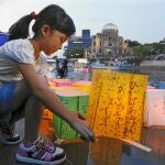Una niña coloca una linterna de papel en el río Motoyasu en memoria de las víctimas de Hiroshima