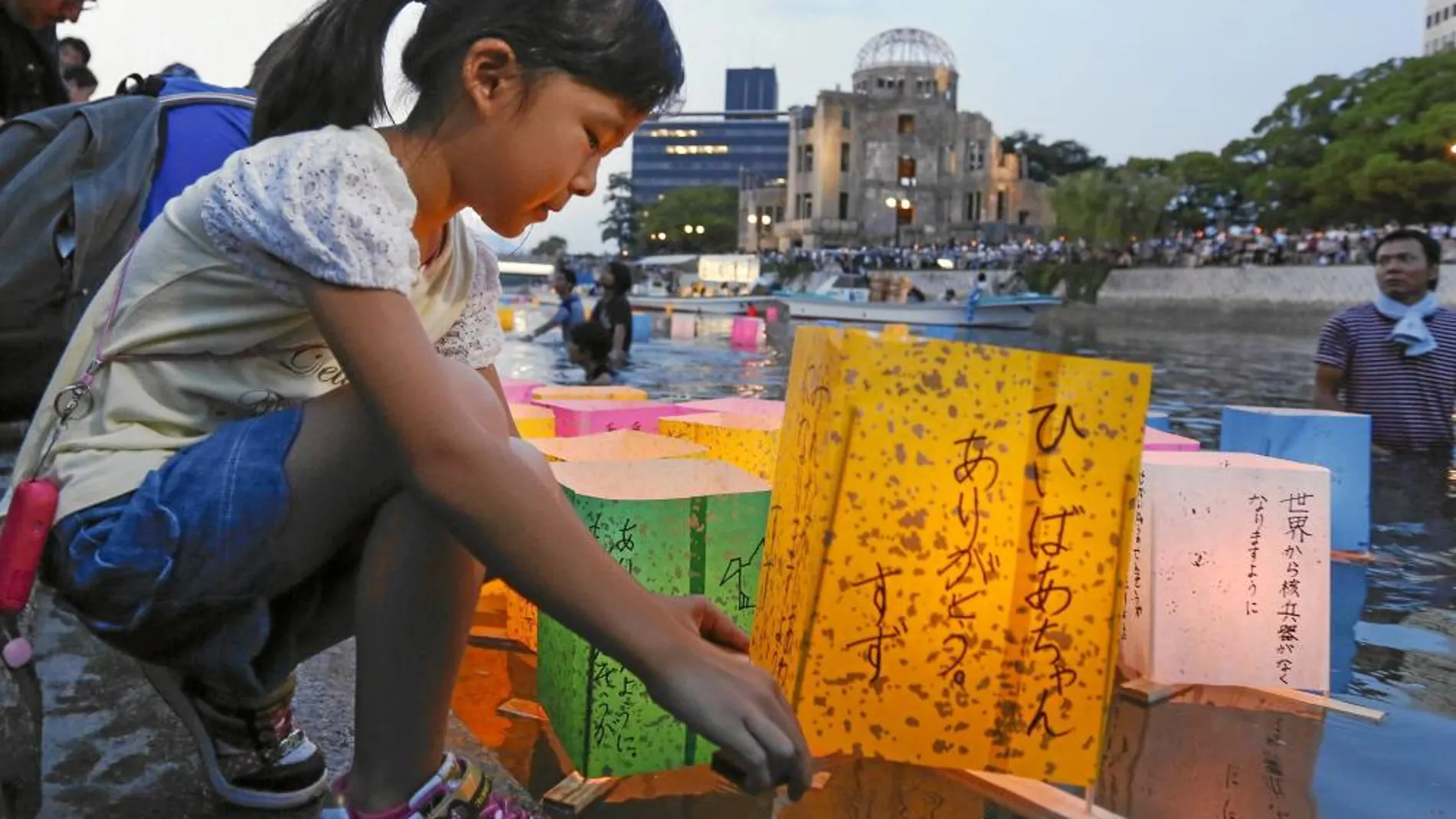 Una niña coloca una linterna de papel en el río Motoyasu en memoria de las víctimas de Hiroshima