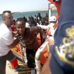 Personal de Cruz Roja ayuda a los 59 inmigrantes de origen subsahariano tras ser rescatados hoy por Salvamento Marítimo cuando intentaban alcanzar las costas españolas a bordo de cuatro pateras en aguas del estrecho de Gibraltar a su llegada al puerto de Tarifa