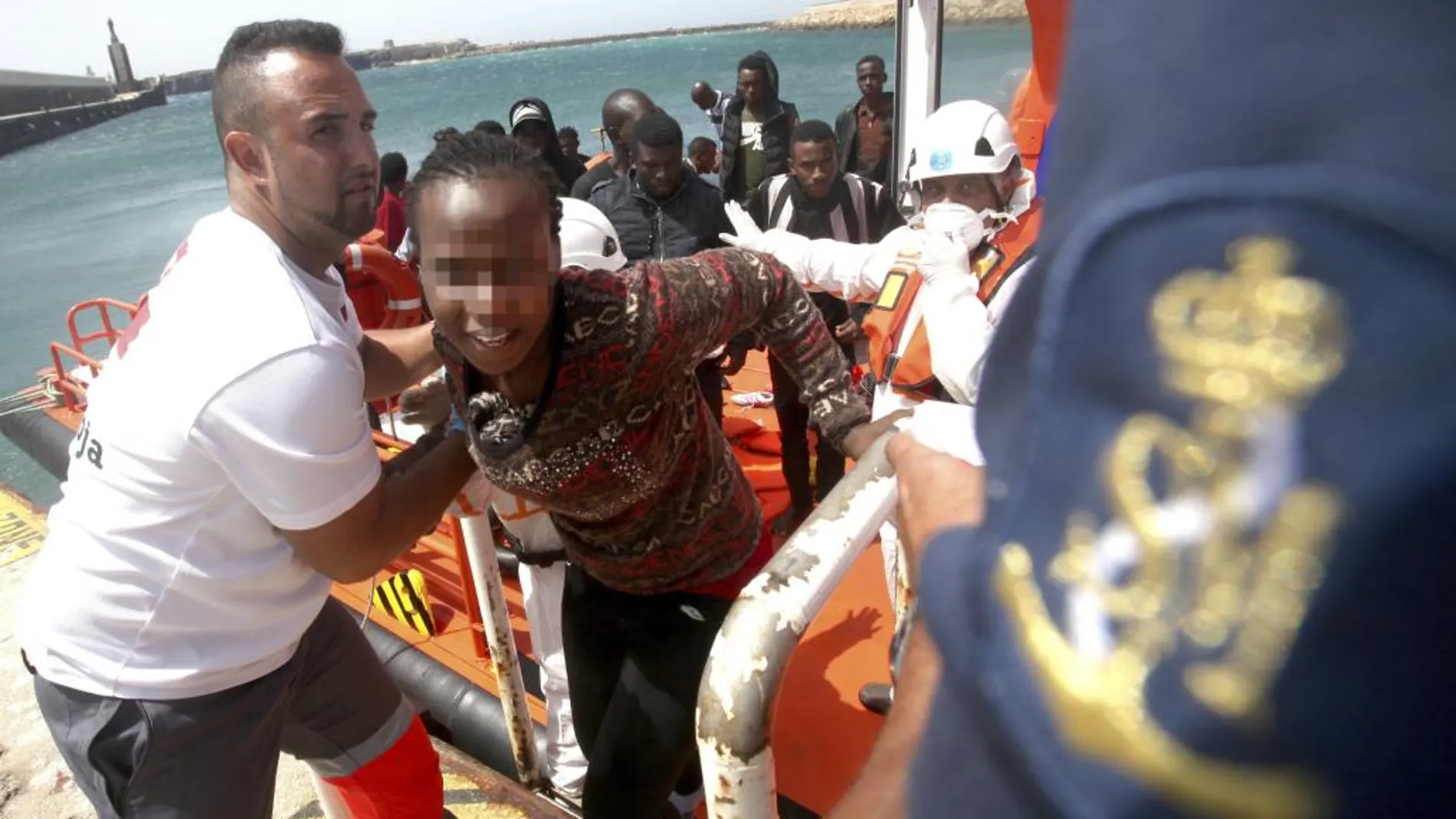 Personal de Cruz Roja ayuda a los 59 inmigrantes de origen subsahariano tras ser rescatados hoy por Salvamento Marítimo cuando intentaban alcanzar las costas españolas a bordo de cuatro pateras en aguas del estrecho de Gibraltar a su llegada al puerto de Tarifa