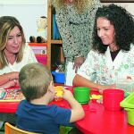 La presidenta de la Junta de Andalucía, Susana Díaz (i), observa a un niño jugar durante su visita a la asociación de personas con discapacidad 'La Canariega".