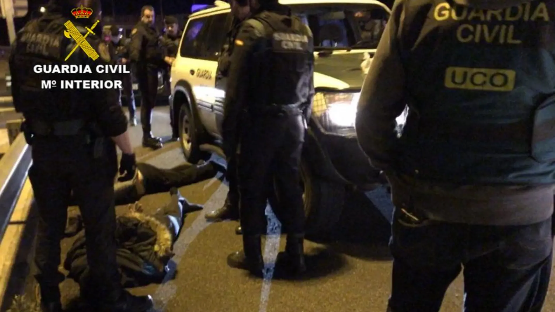 Tres agentes custodian a uno de los detenidos, tendido sobre el suelo