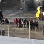 Inmigrantes subsaharianos rodeados por la Policía marroquí, en el perímetro fronterizo de Ceuta