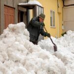 Un hombre retira la nieve de la puerta de su casa en la localidad de Pedrafita do Cebreiro, en Lugo