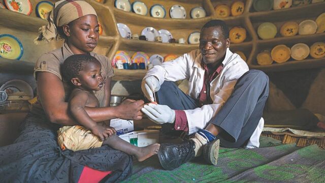 Un médico local realiza una prueba de diabetes a un pequeño en una localidad de Kenia