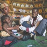 Un médico local realiza una prueba de diabetes a un pequeño en una localidad de Kenia