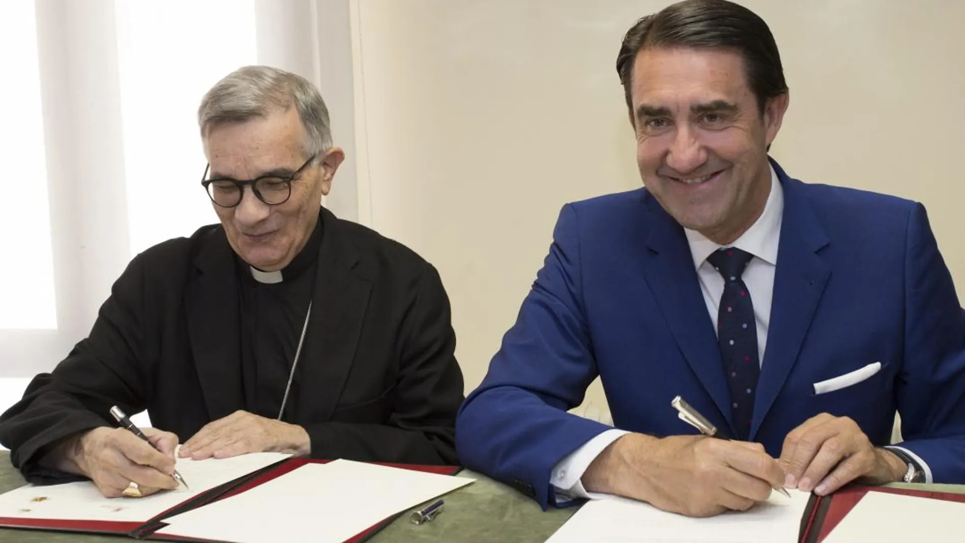 El consejero Suárez-Quiñones y el obispo de Segovia, César Franco, suscriben el acuerdo