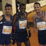 Neguse Amloson, c, ganador de la carrera internacional de la San Silvestre Vallecana acompañado del español Ilias Fifam,iz, segundo clasifiacado y Antonio Abadía,tercero, posan tras cruzar la meta de la prueba en el estadio de Vallecas