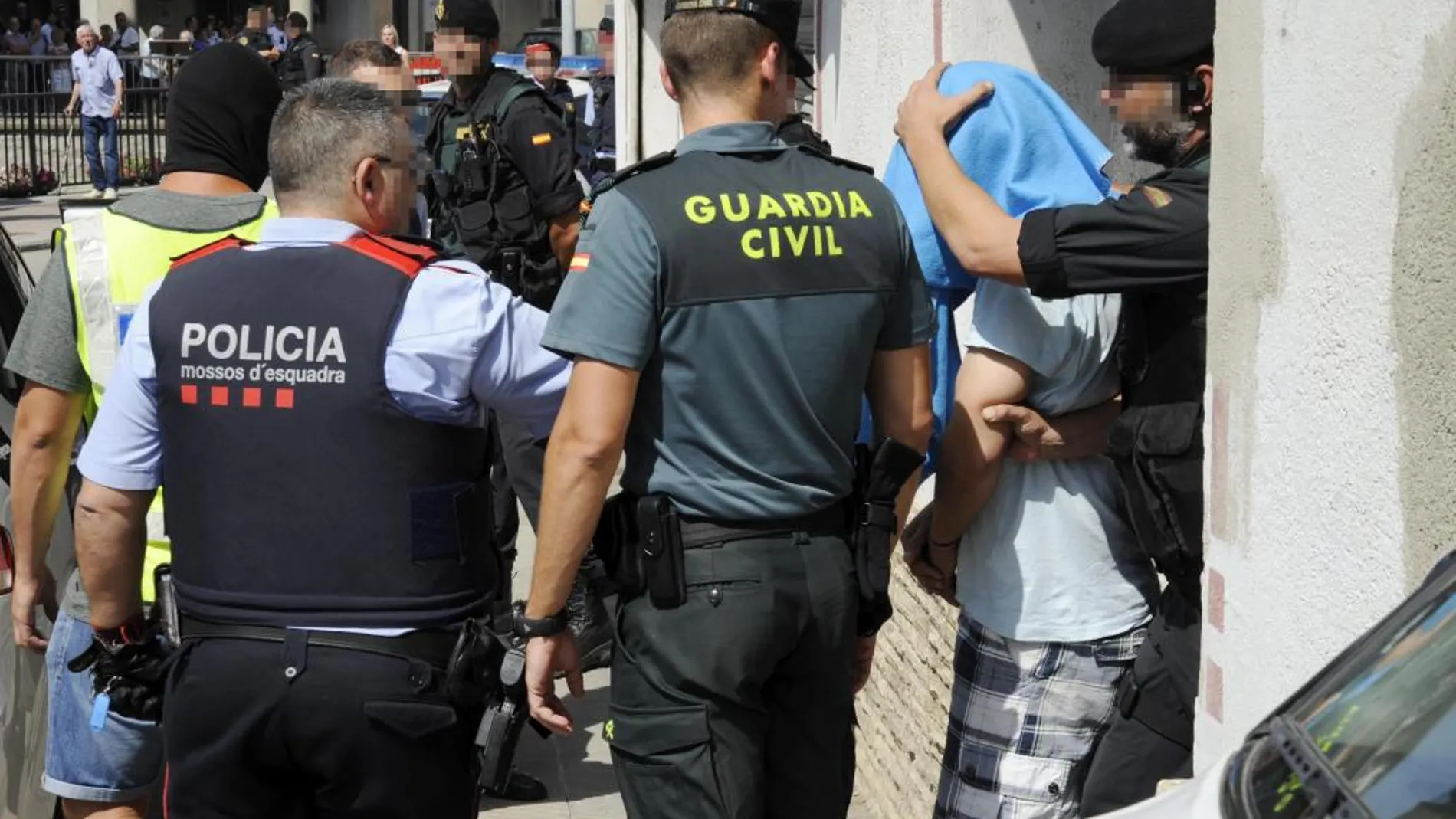 Guardia Civil y Mossos d'Esquadra se llevan a un detenido en Ripoll.