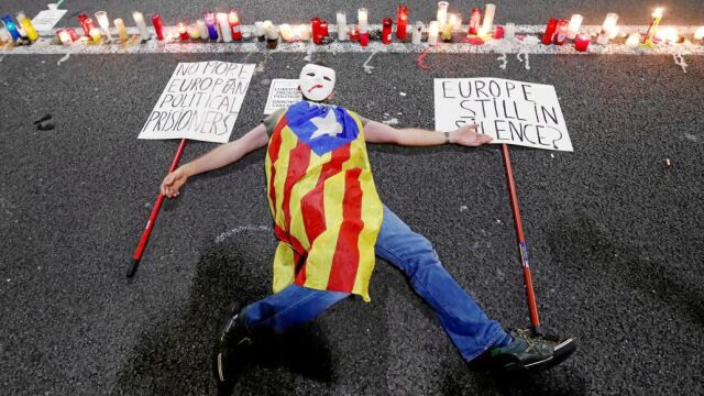 Marta Rovira intentó hacernos creer que el Gobierno le amenazó con poner muertos en las calles. En la imagen, un secesionista se cubre con la estelada en una protesta