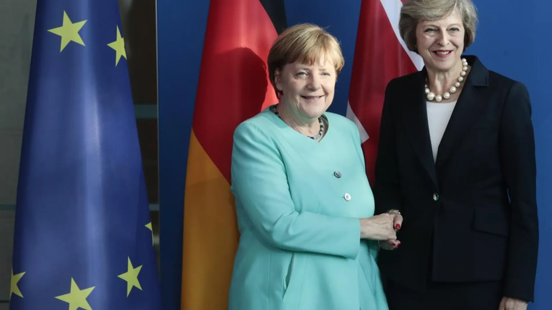 La canciller alemana, Angela Merkel (i), estrecha la mano de la primera ministra británica, Theresa May, durante una rueda de prensa conjunta en la Cancillería de Berlín