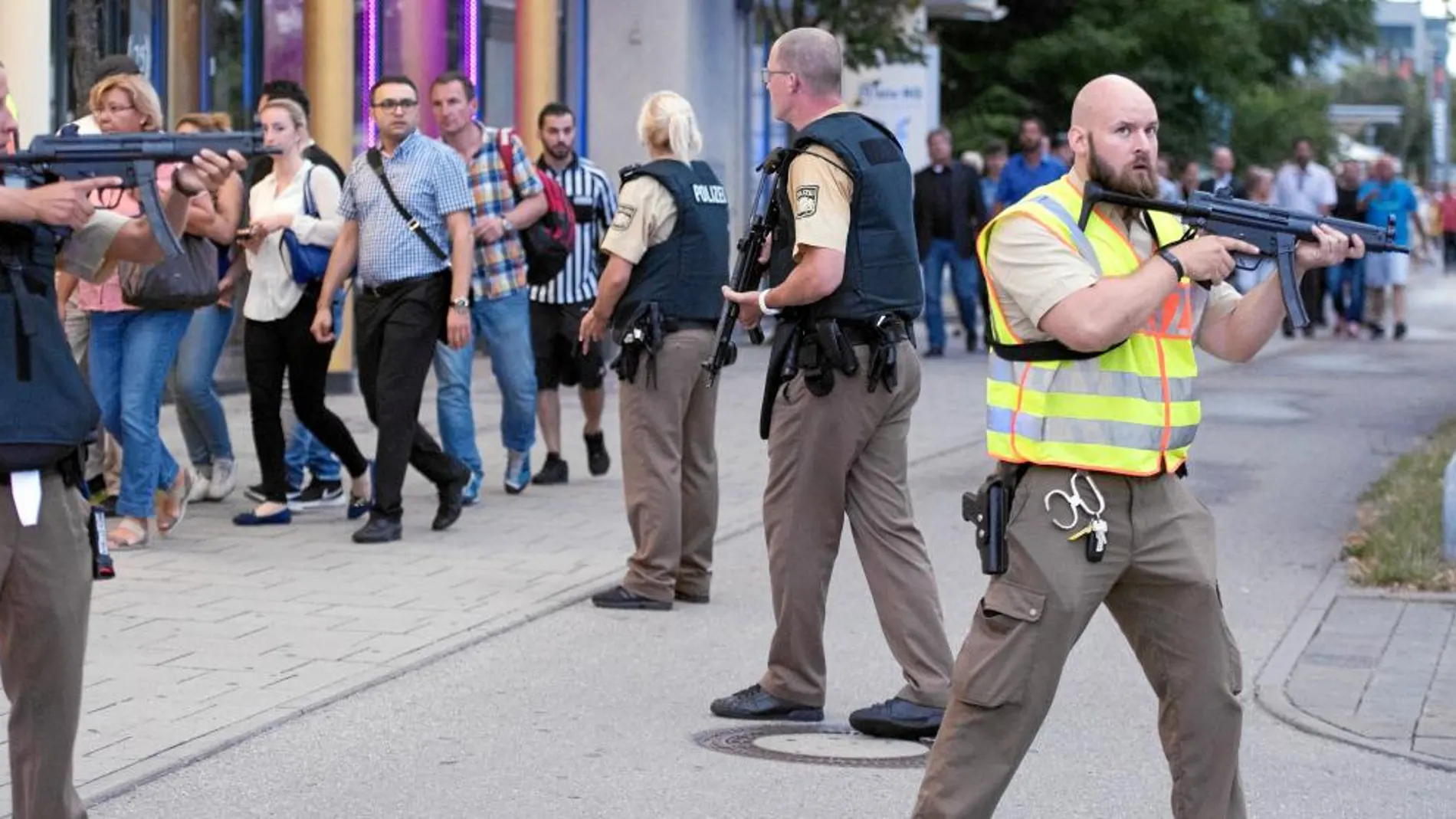 Fuerzas policiales escoltan a varias de las personas que se encontraban dentro del atacado centro comercial Olympia, ayer tras el tiroteo en Munich.