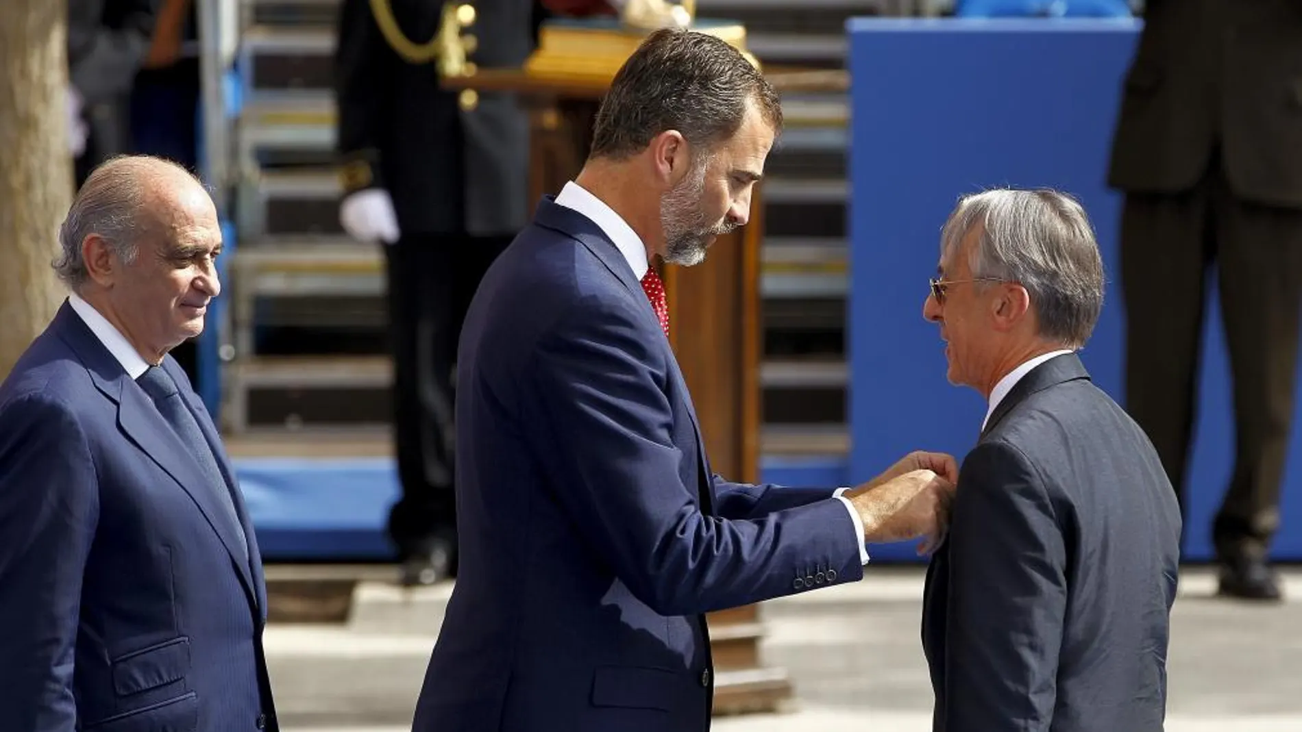 El Príncipe Felipe acompañado por el ministro del Interior, Jorge Fernández Díaz (izq.), impone la medalla de plata al director general de la Policía de Francia, Claude Baland, durante los actos centrales del Día de la Policía