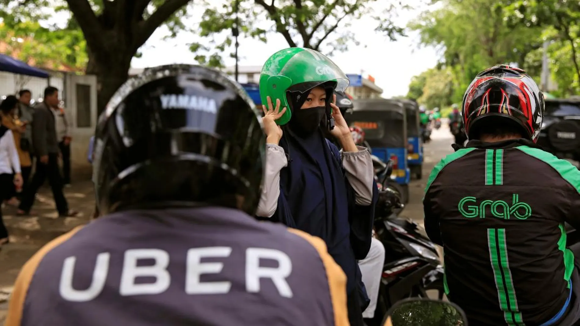Un conductor vietnamita de la compañía Uber y su pasajero viajan en una motocicleta por las calles de Hanoi, (Vietnam). Efe