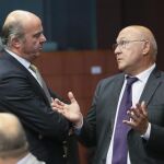 Luis de Guindos conversa con el ministro de Finanzas francés, Michel Sapin (d) durante la reunión del Eurogrupo del pasado 11 de julio