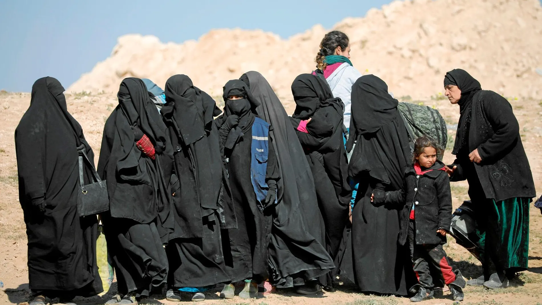 Un grupo de mujeres huye ayer de la localidad de Baghuz, en la provincia de Deir Al Zor, el último bastión del Estado Islámico en el país