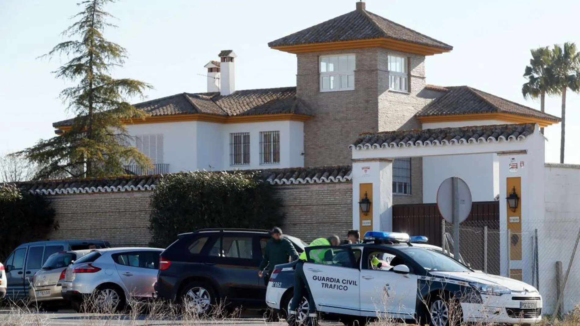 Efectivos de la Guardia Civil en la puerta de la vivienda ubicada en la carretera que une Almensilla y Mairena del Aljarafe, en el término municipal de esta última localidad sevillana, donde ha muerto una persona que estaba participando en un atraco