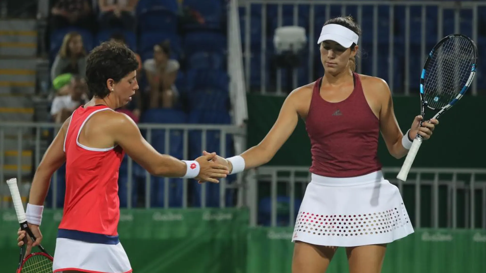 La española Carla Suárez (i) saluda a su compañera Garbiñe Muguruza (d) ante la pareja brasileña compuesta por Paula Goncalves y Teliana Pereira durante el partido de dobles