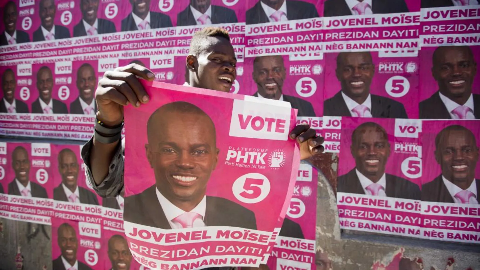 Un seguidor de Jovenel Moise, con un cartel electoral, celebra el triunfo anunciado por el Consejo Electoral