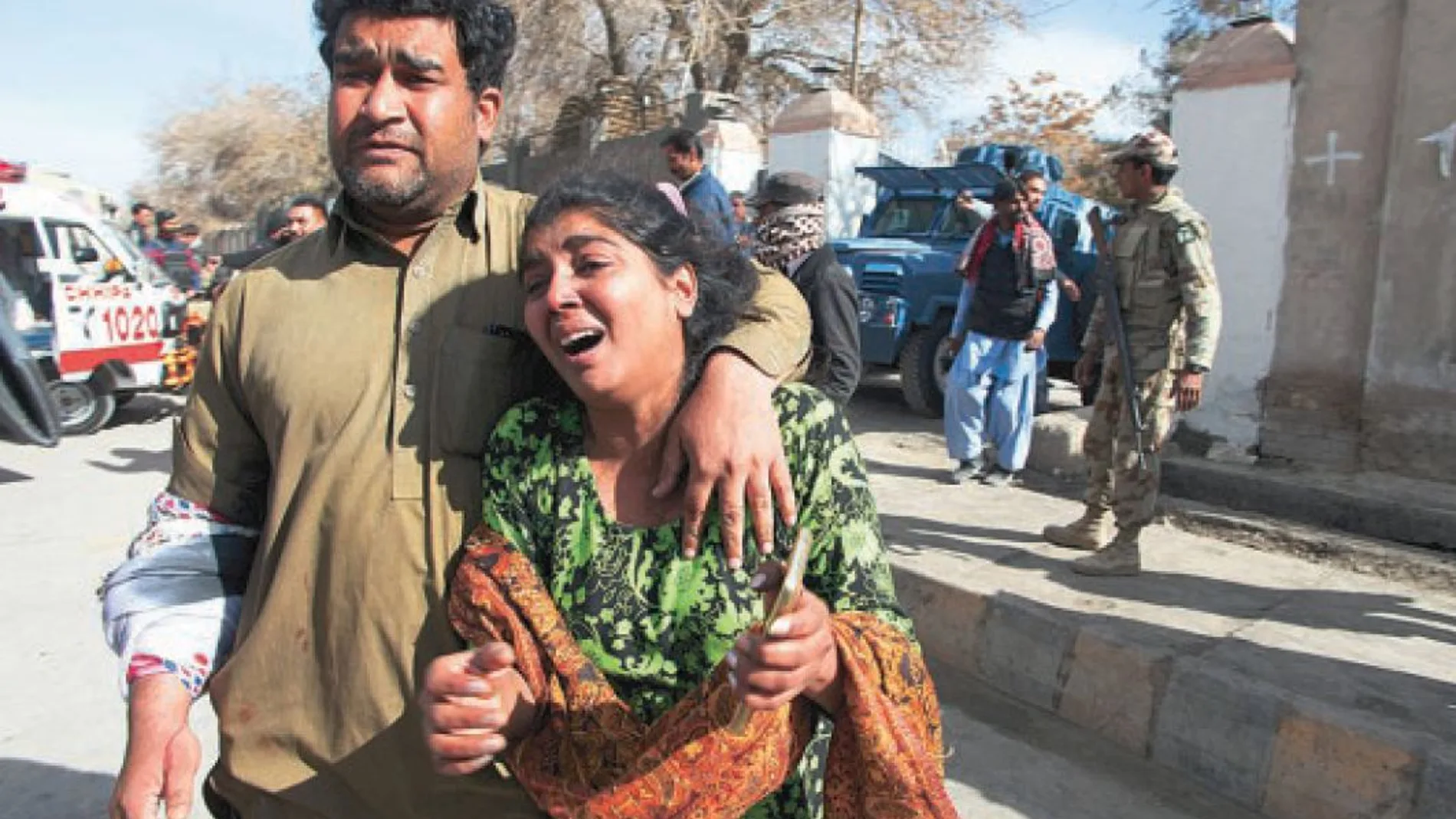 Un hombre y una mujer paquistaníes abandonan conmocionados la iglesia metodista atacada ayer por el Estado Islámico en la ciudad de Quetta