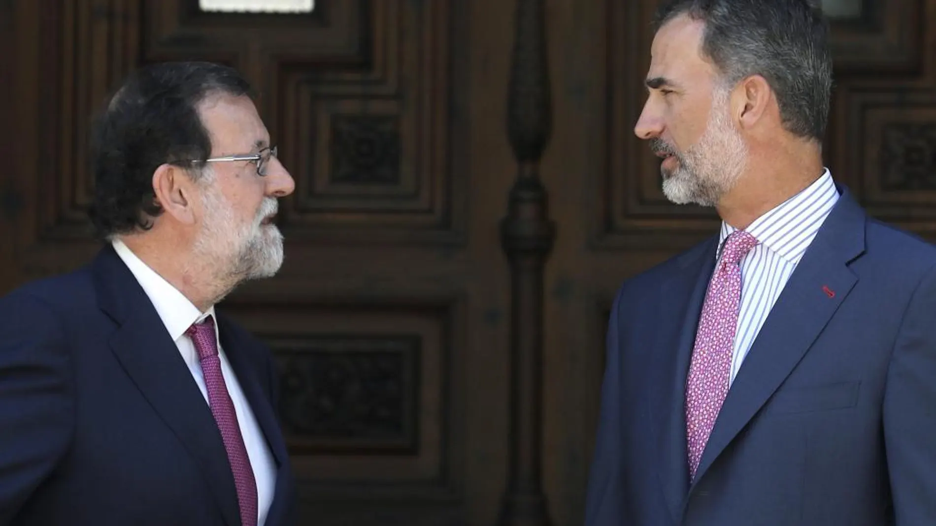 El Rey Felipe VI y el presidente del Gobierno, Mariano Rajoy, en la entrada del Palacio de Marivent, poco antes del tradicional despacho de verano