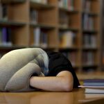 Un estudiante se echa una siesta rápida en una biblioteca/Efe