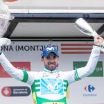 Valverde, vestido con el maillot de líder de la Volta, el trofeo de ganador en la izquierda y el ramo de flores en la derecha