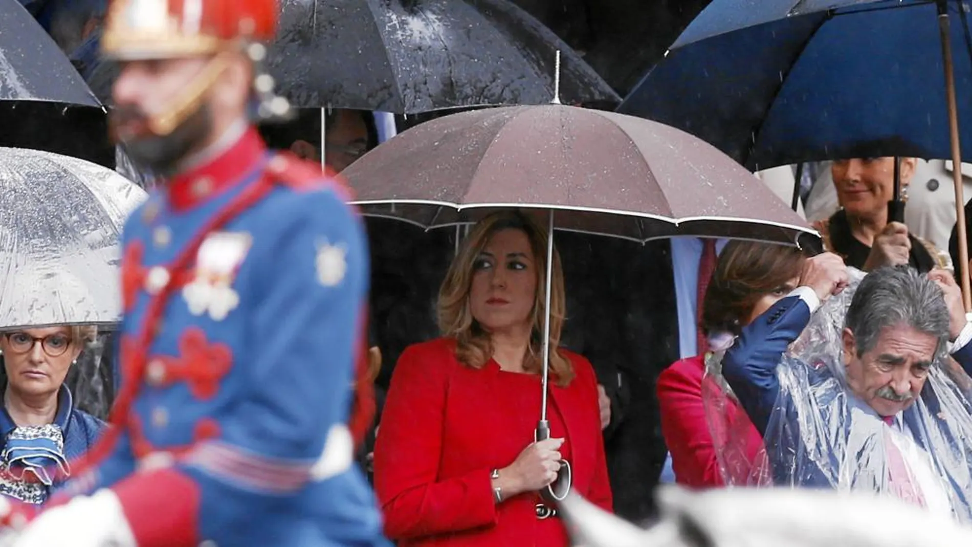 La presidenta andaluza, Susana Díaz, se protege ayer de la lluvia durante el desfile militar del 12 de Octubre