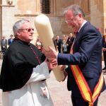 El abad de la Colegiata de San Isidoro, Francisco Rodríguez Llamazares, recibe un cirio de manos del alcalde Antonio Silván