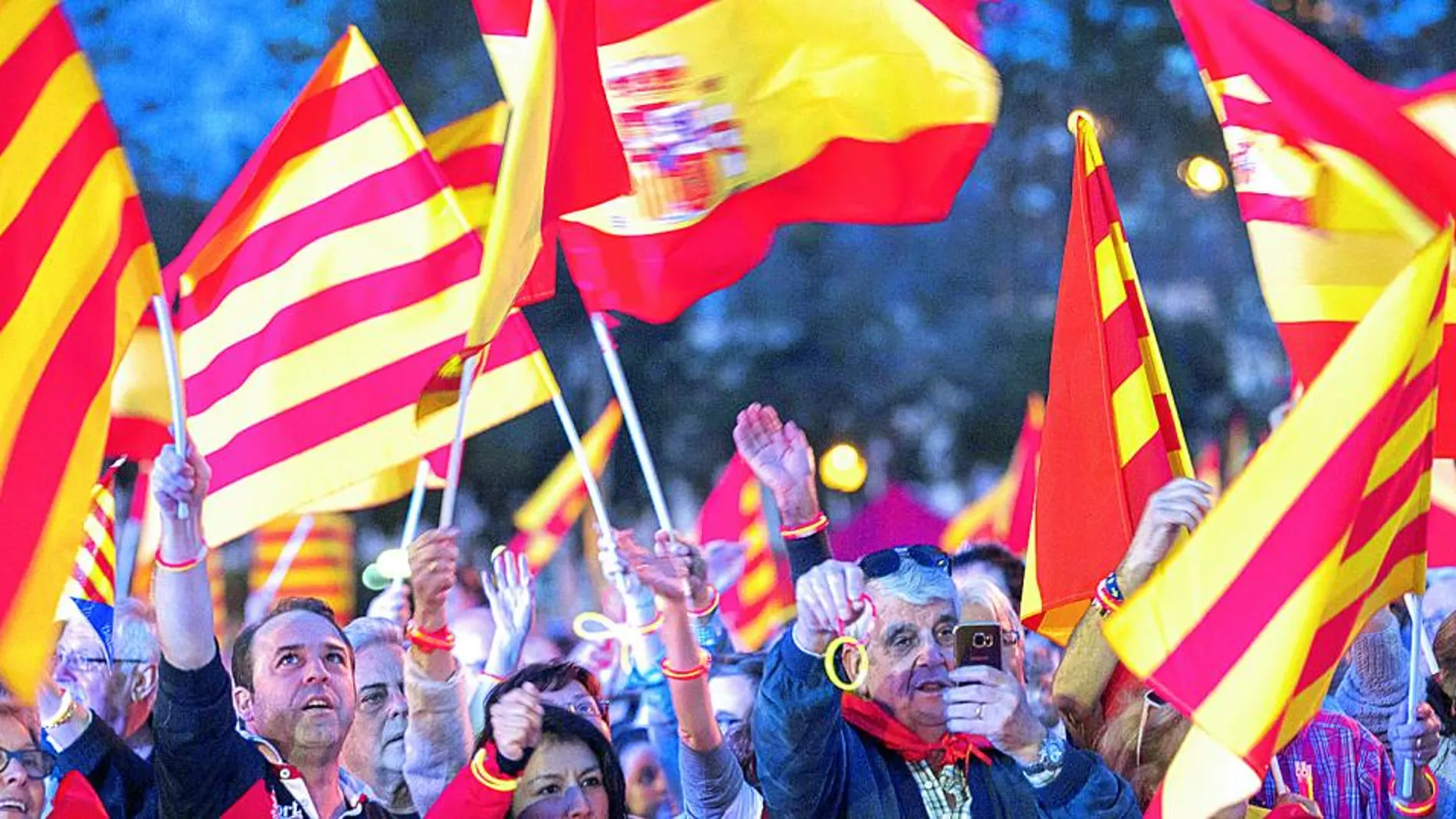 Manifestantes muestran banderas catalanas y españolas durante la celebración.