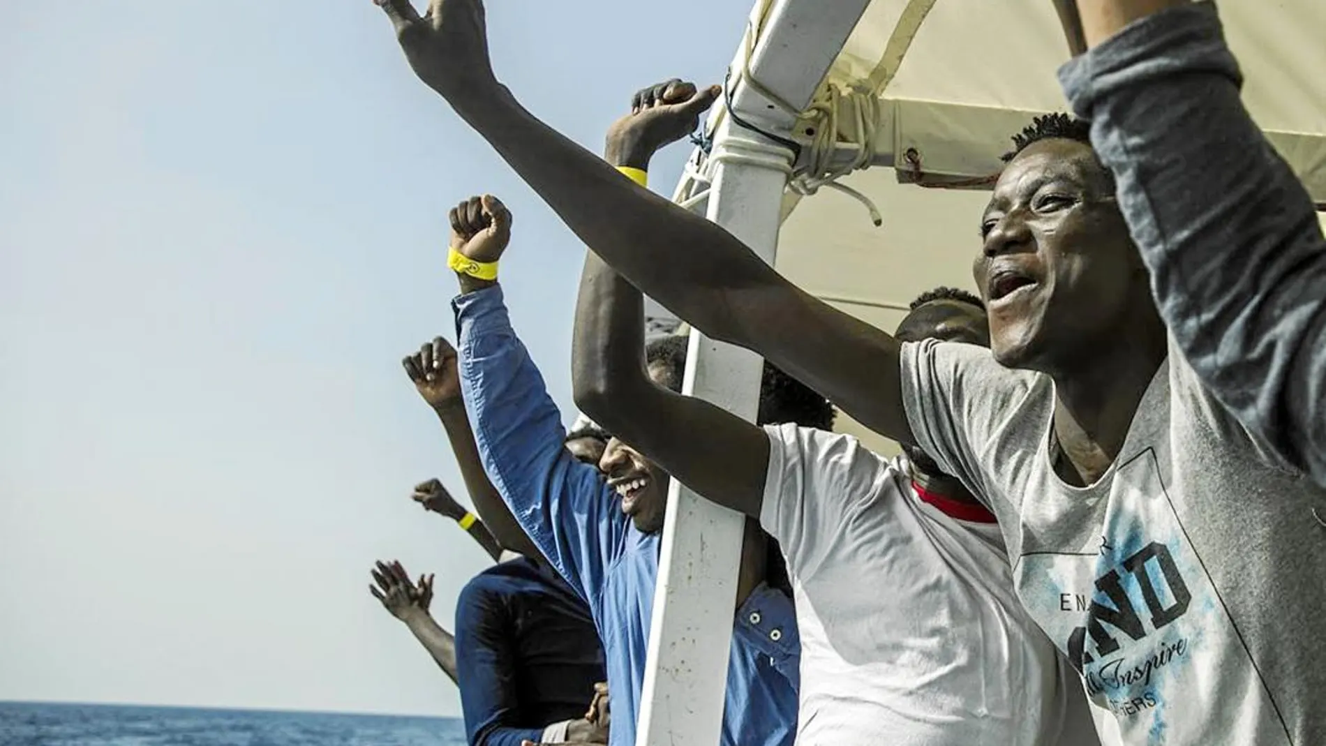 Los migrantes celebran su rescate ya a bordo del barco de la ONG española Proactiva / Ap