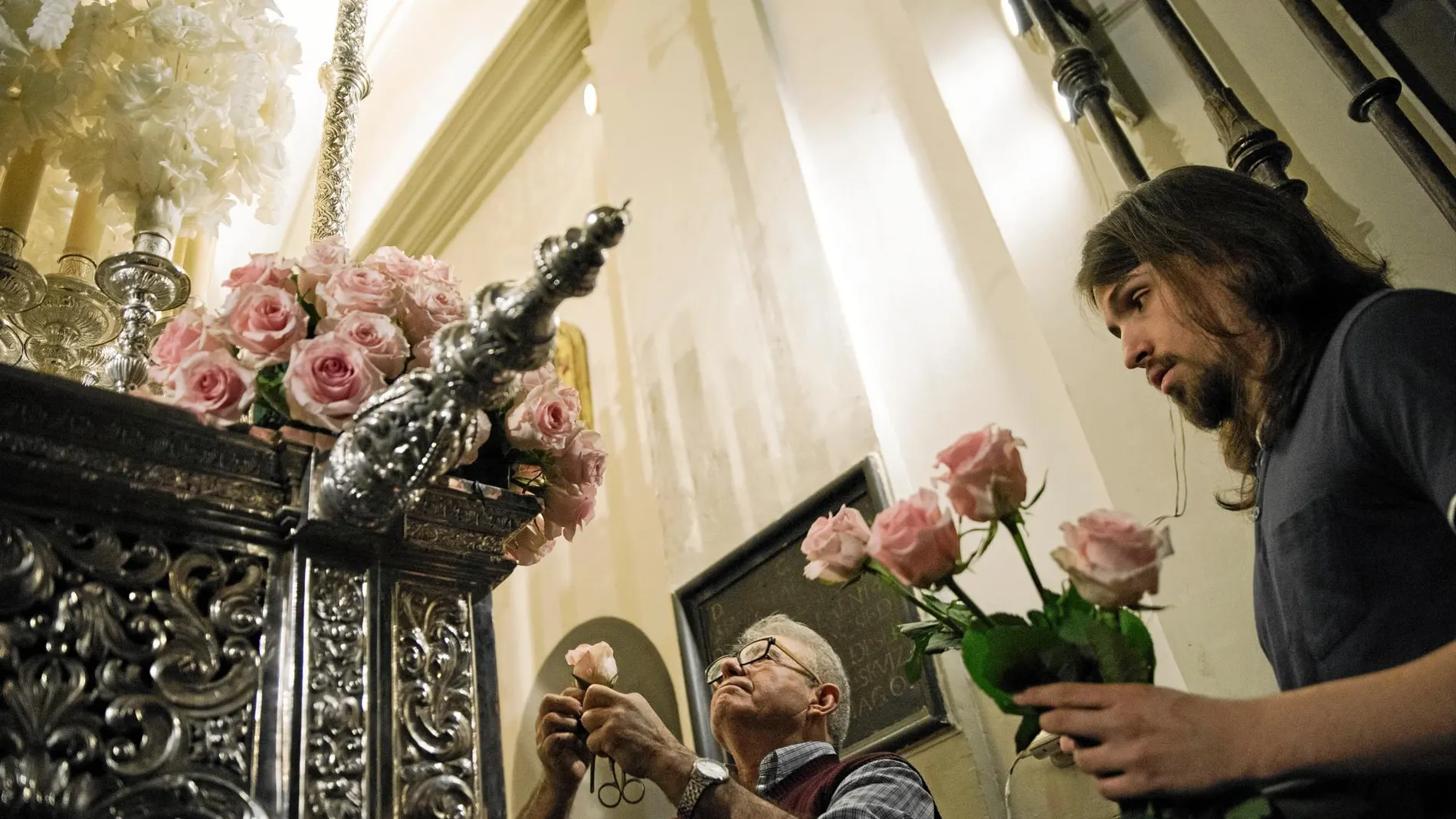 Daniel Ejido ayuda a Guillermo a colocar las flores del palio con el que procesionará hoy la Virgen Esperanza Macarena por las calles de Madrid. Foto: David Jar