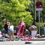 Gente buscando ropa y comida entre los restos de un mercadillo ambulante en Madrid.