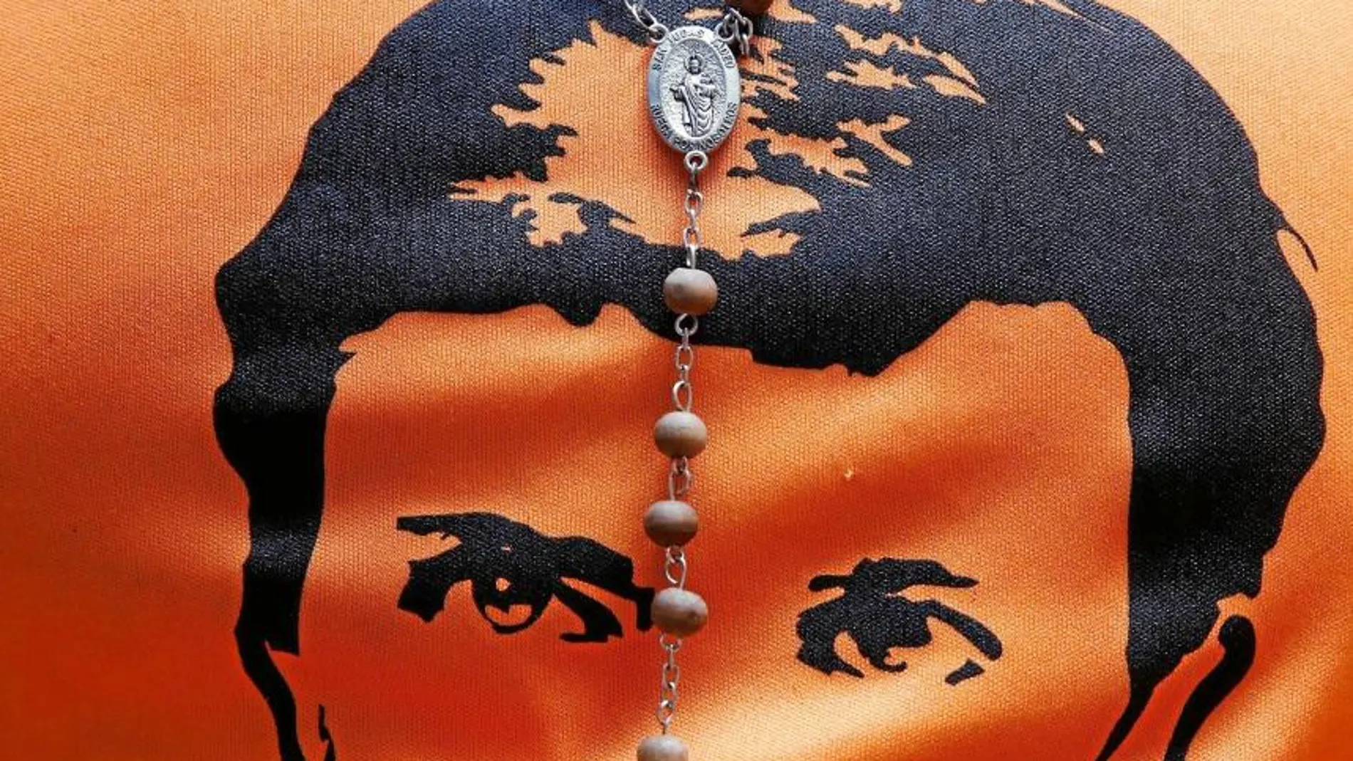 Un crucifijo sobre una camiseta con el rostro de Leopoldo López