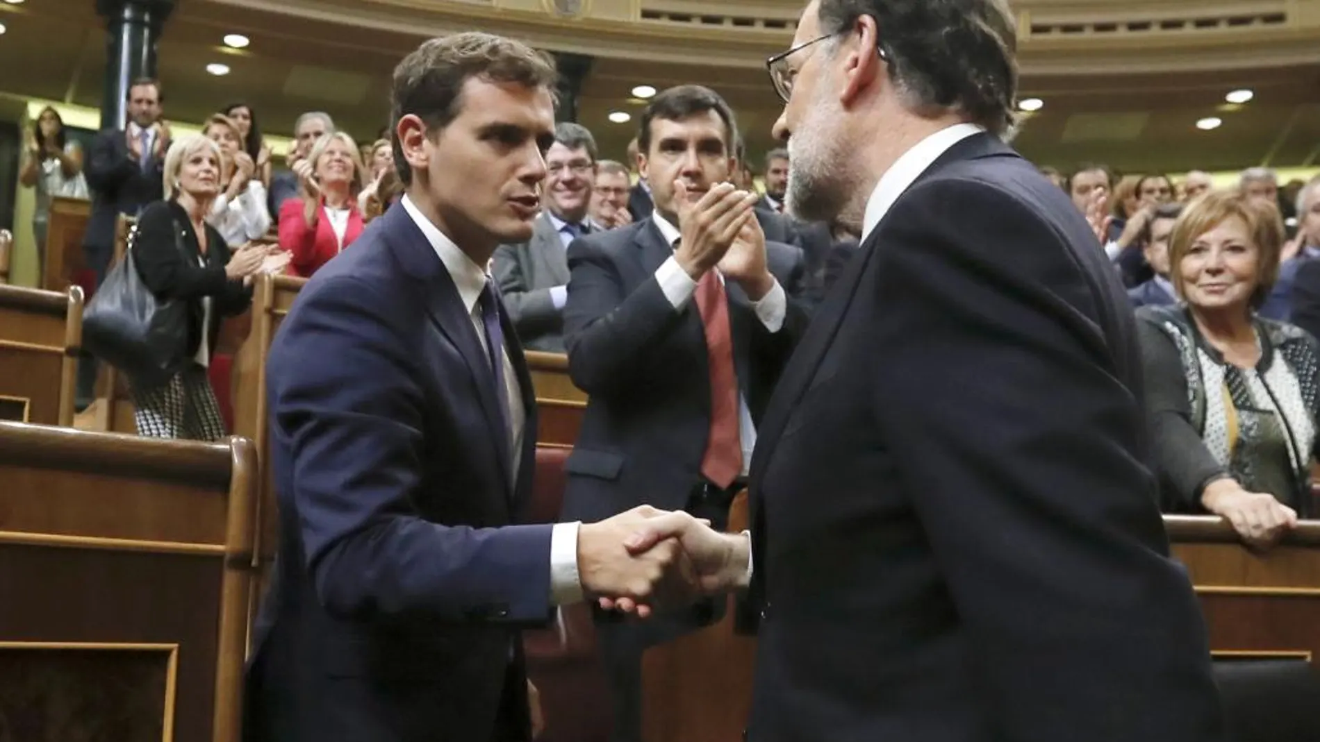El líder del PP y presidente del Gobierno en funciones, Mariano Rajoy (d), es felicitado por el líder de Ciudadanos, Albert Rivera, tras ser investido hoy presidente del Gobierno