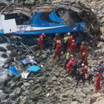 Fotografía cedida por la Agencia Andina, de un grupo de bomberos y policías durante las labores de rescate de un autobús siniestrado
