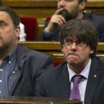 El ex presidente de la Generalitat, Carles Puigdemont y el ex vicepresidente del Govern, Oriol Junqueras en una imagen de archivo en el Parlament