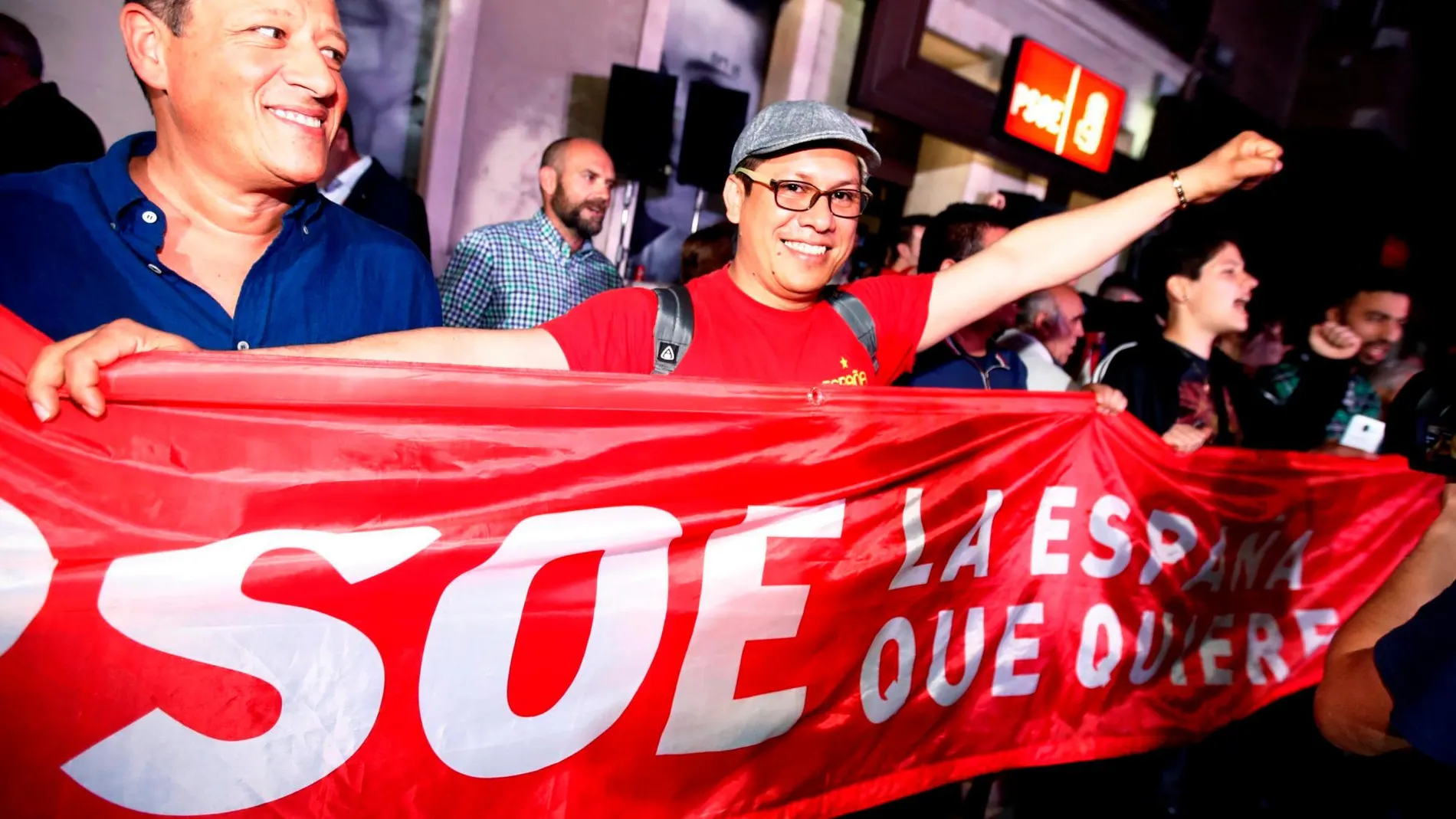 Personas congregadas a las puertas de la sede del PSOE en Madrid desde donde siguen el escrutinio de las elecciones. EFE/ Javier López