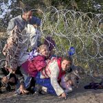 Inmigrantes sirios cruzan la valla de espino para entrar en Hungría desde Serbia en una imagen de archivo de agosto de 2015